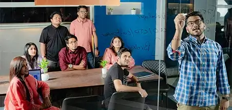 A in house IT company employees are doing group session where a man write something